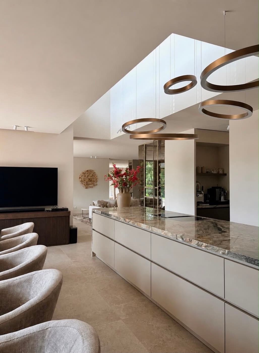 Luxe open keuken met marmeren kookeiland en ronde hanglampen